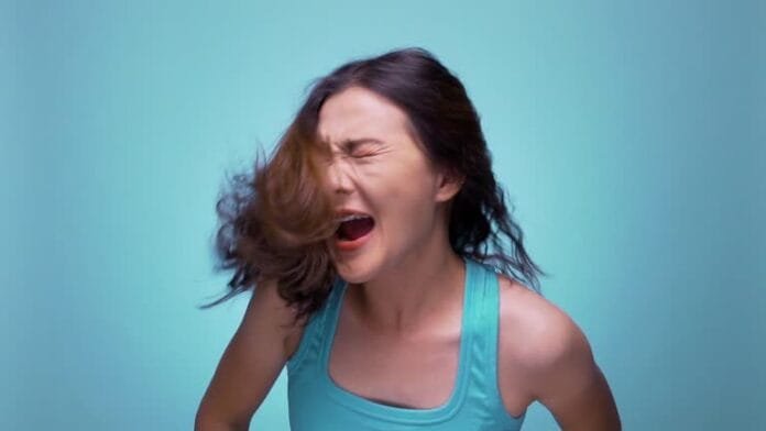 Shouting woman on isolated blue background slow motion